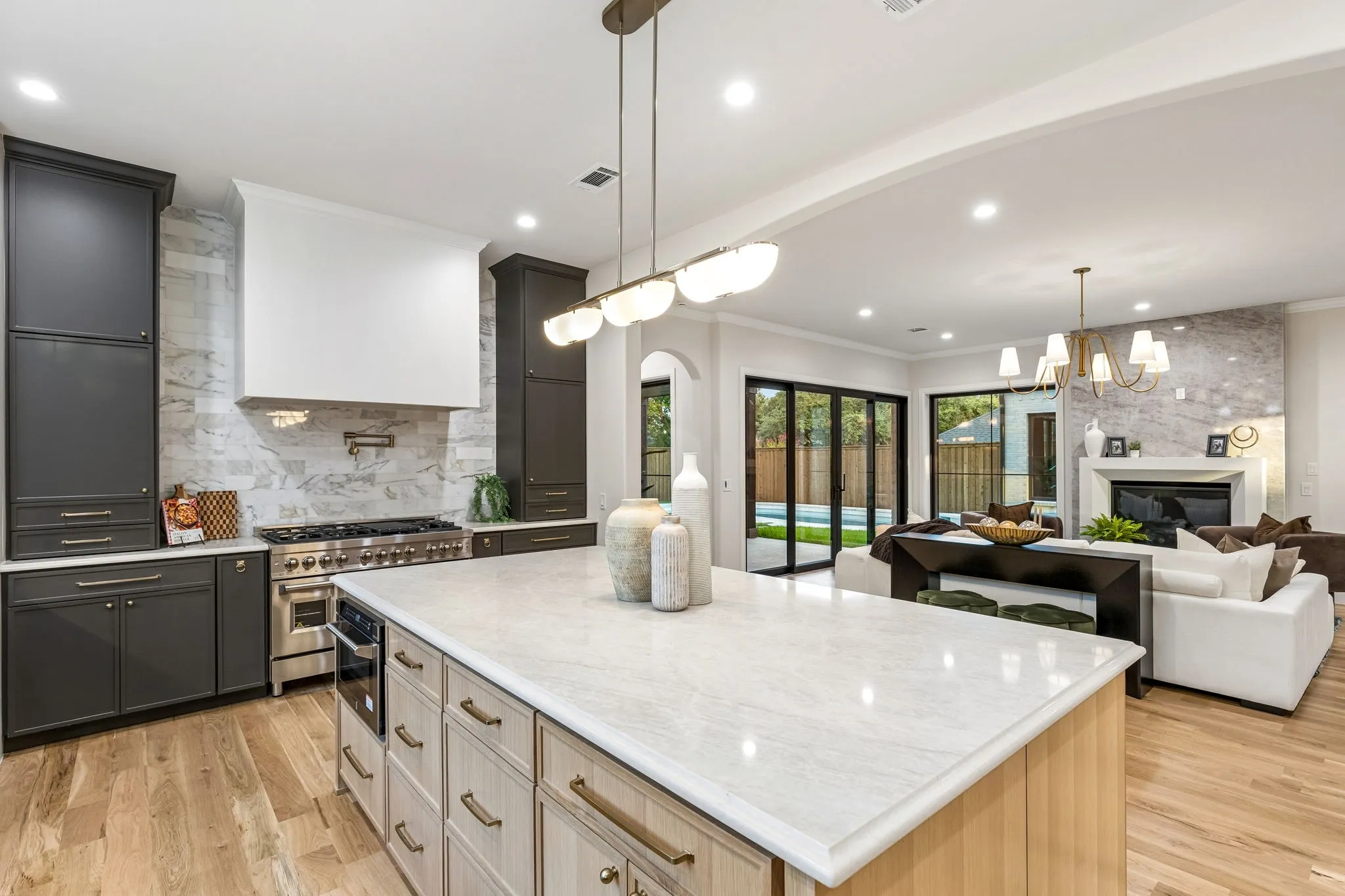 Chef's kitchen with large center island overlooking the living room and backyard oasis