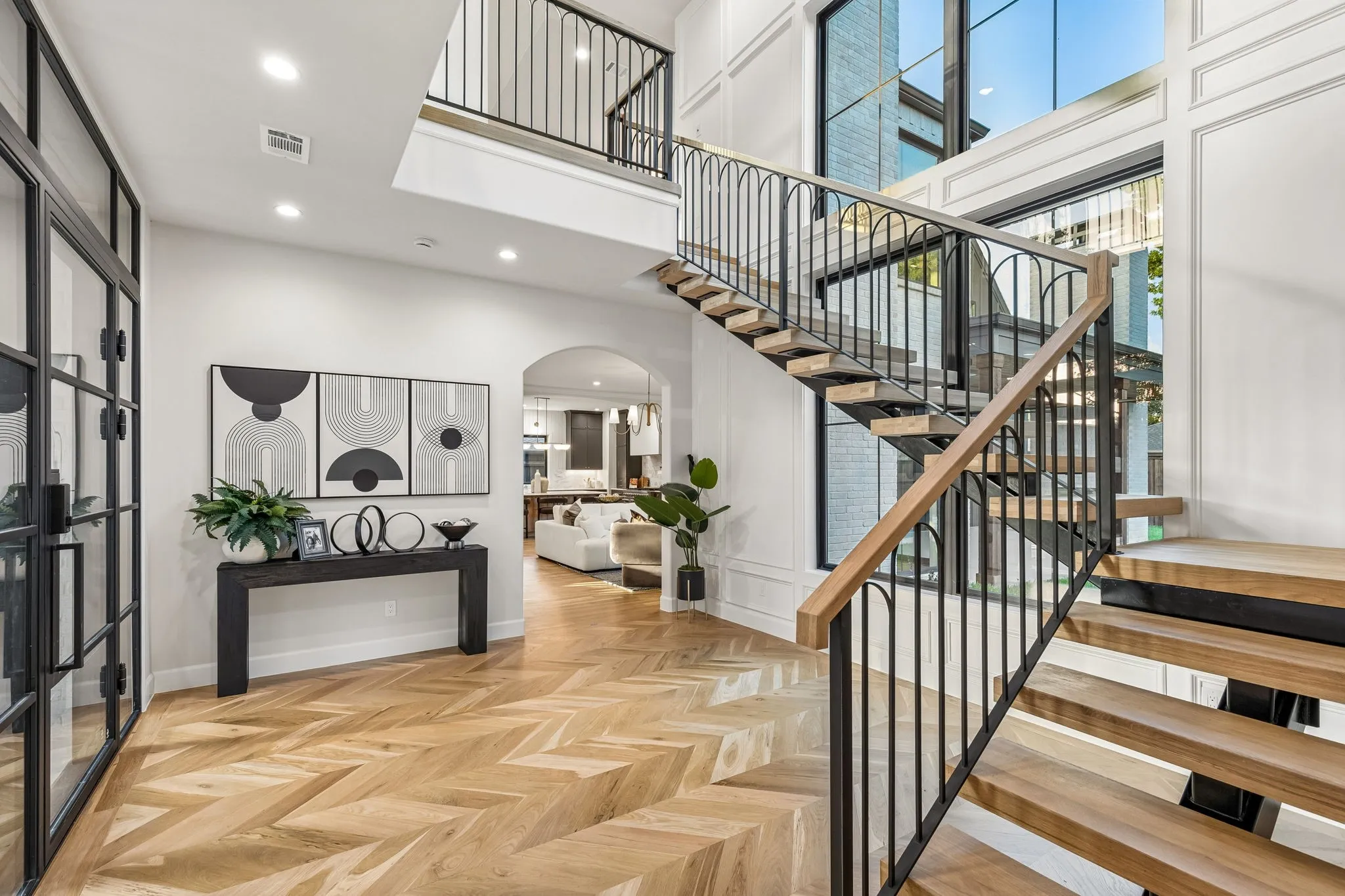 Entry Foyer with Iron front door, large window that provides natural lighting and an iron staircase with 3 inch white oak treads