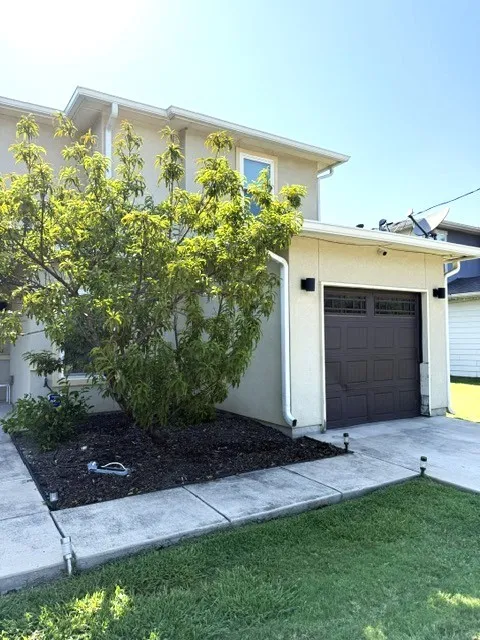 Cream stucco exterior with a dark brown paneled garage door