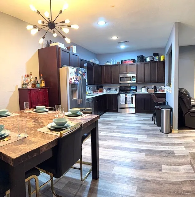 Dining area featuring a modern sputnik chandelier and wood-finish flooring