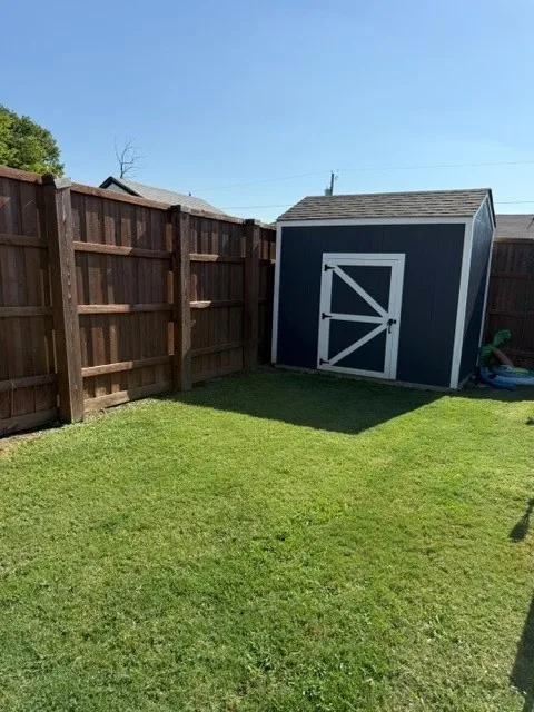 Expansive green lawn with full wood privacy fencing