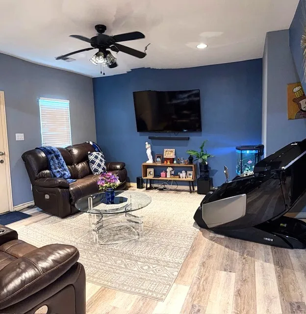 Living area featuring wood-finish flooring, a ceiling fan with integrated lighting, and recessed ceiling lights