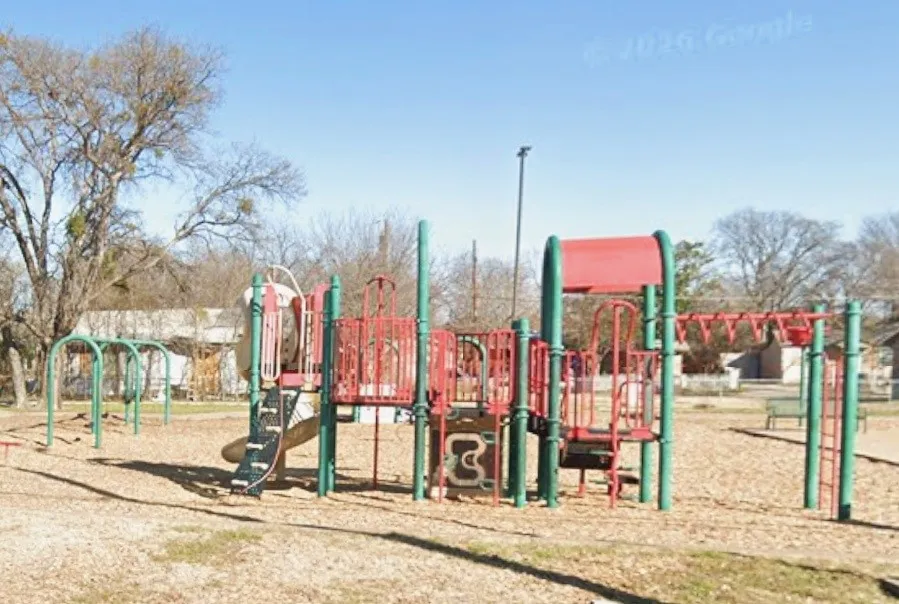 Community playground featuring multi-level play structures, slides, monkey bars, and swings