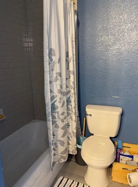 Bathroom featuring a white bathtub and subway tile surround