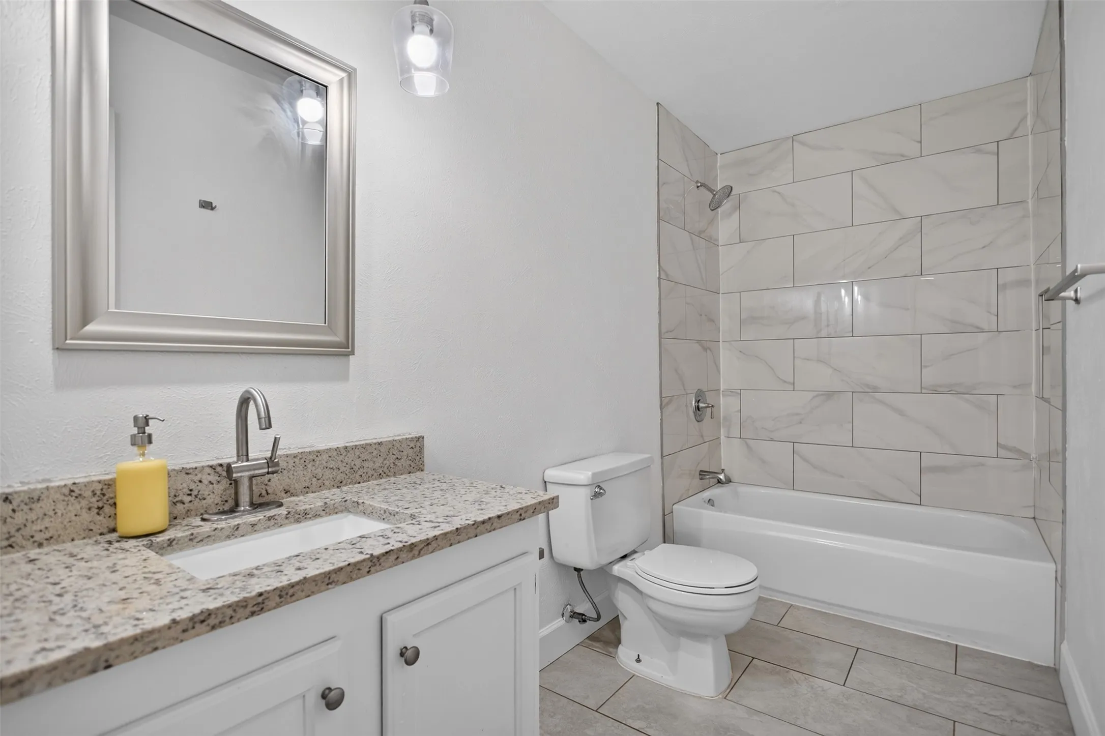 Bathroom featuring a vanity with granite countertop, undermount sink, and brushed nickel faucet