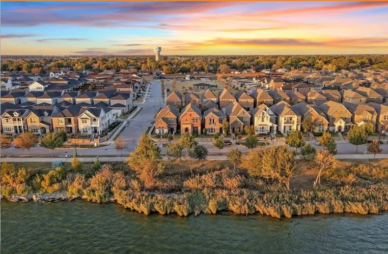Waterfront properties featuring diverse architectural styles, mature trees, and paved streets