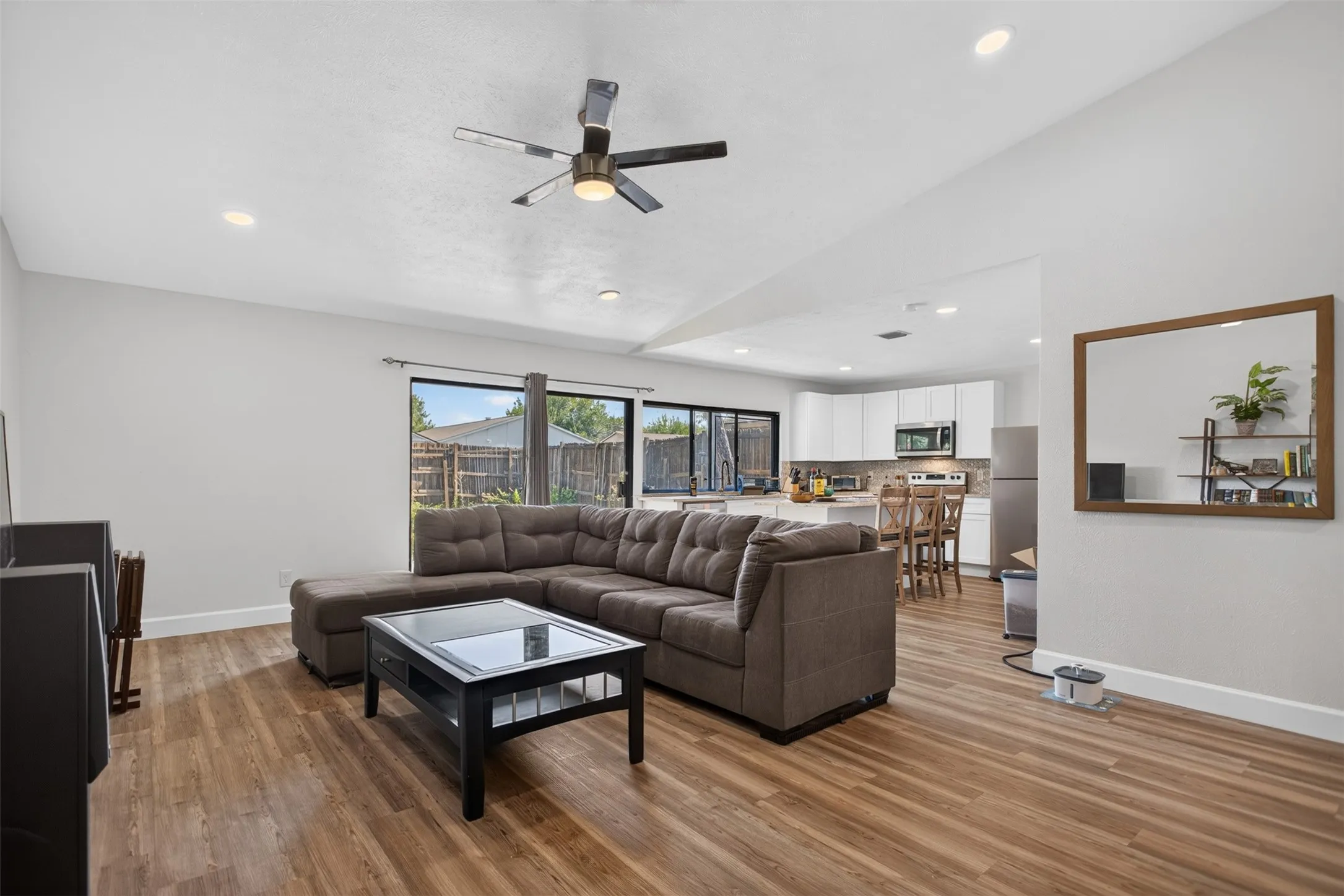 Staged Open-concept living area featuring wood-finish flooring, recessed lighting, and a ceiling fan