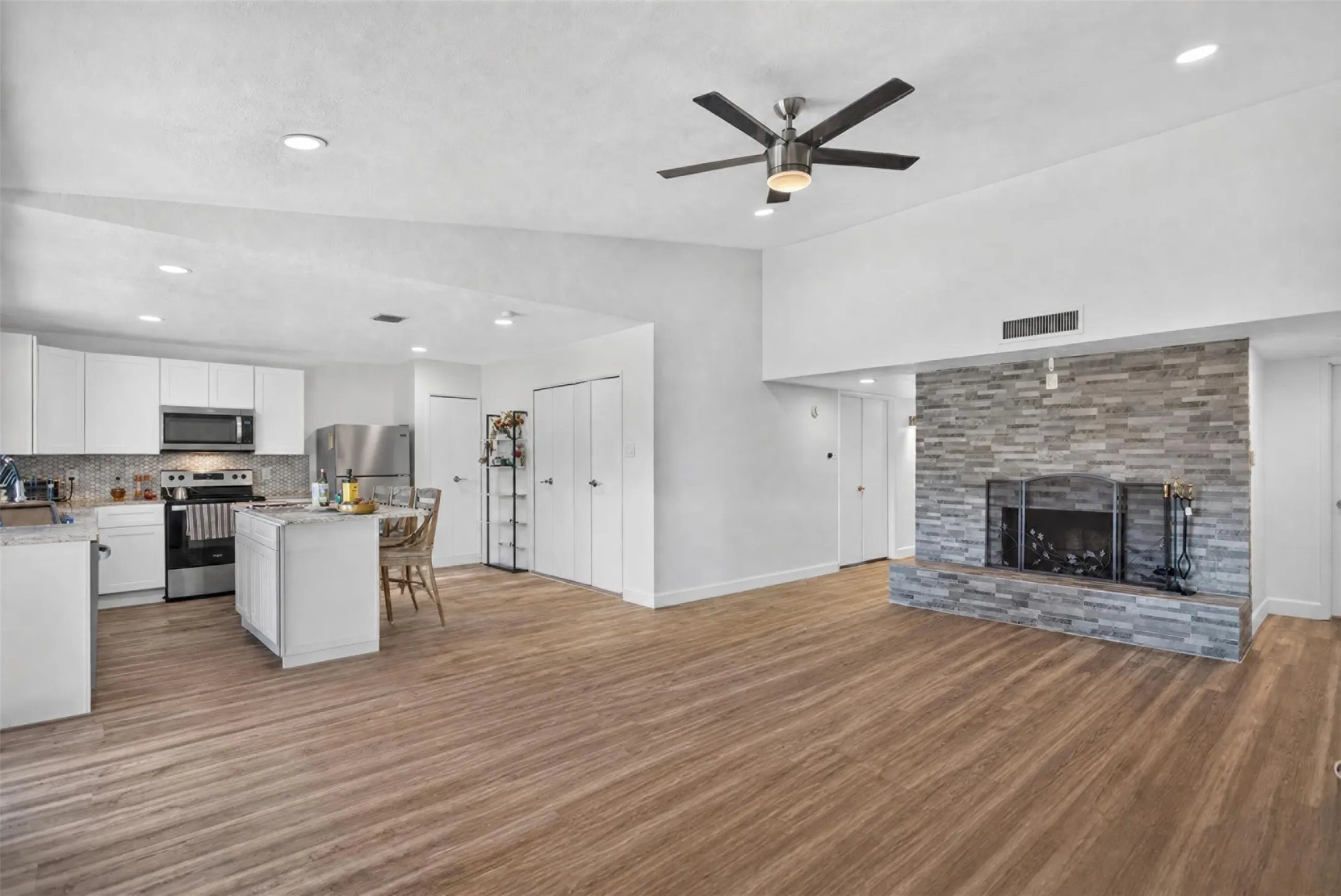 Open-concept living space featuring wood-finish flooring and a vaulted ceiling