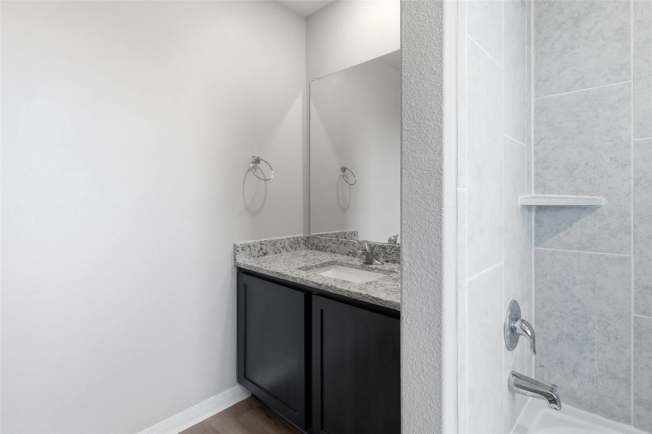 Secondary Bathroom vanity featuring a granite countertop, undermount sink, and dark wood-finish cabinetry