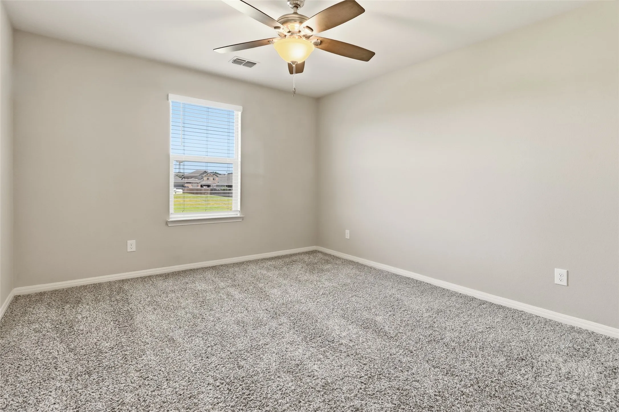 Carpeted room with neutral wall tones and a ceiling fan with integrated lighting