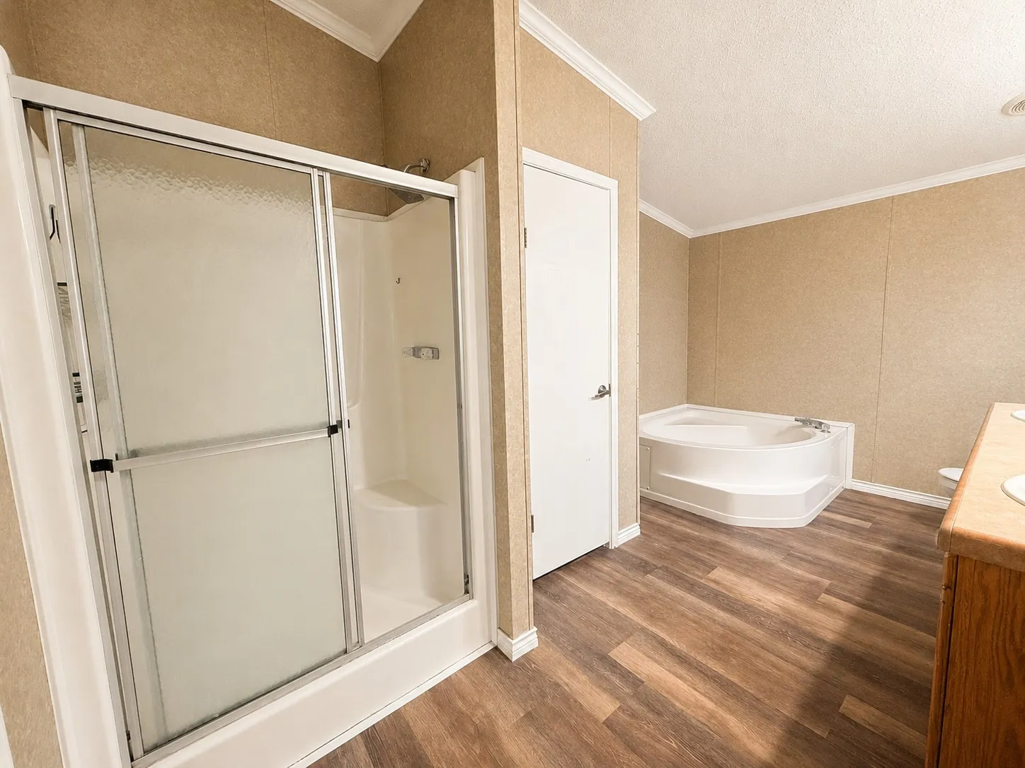 Full bathroom featuring a shower with sliding glass doors, a built-in shower bench, and a corner soaking tub