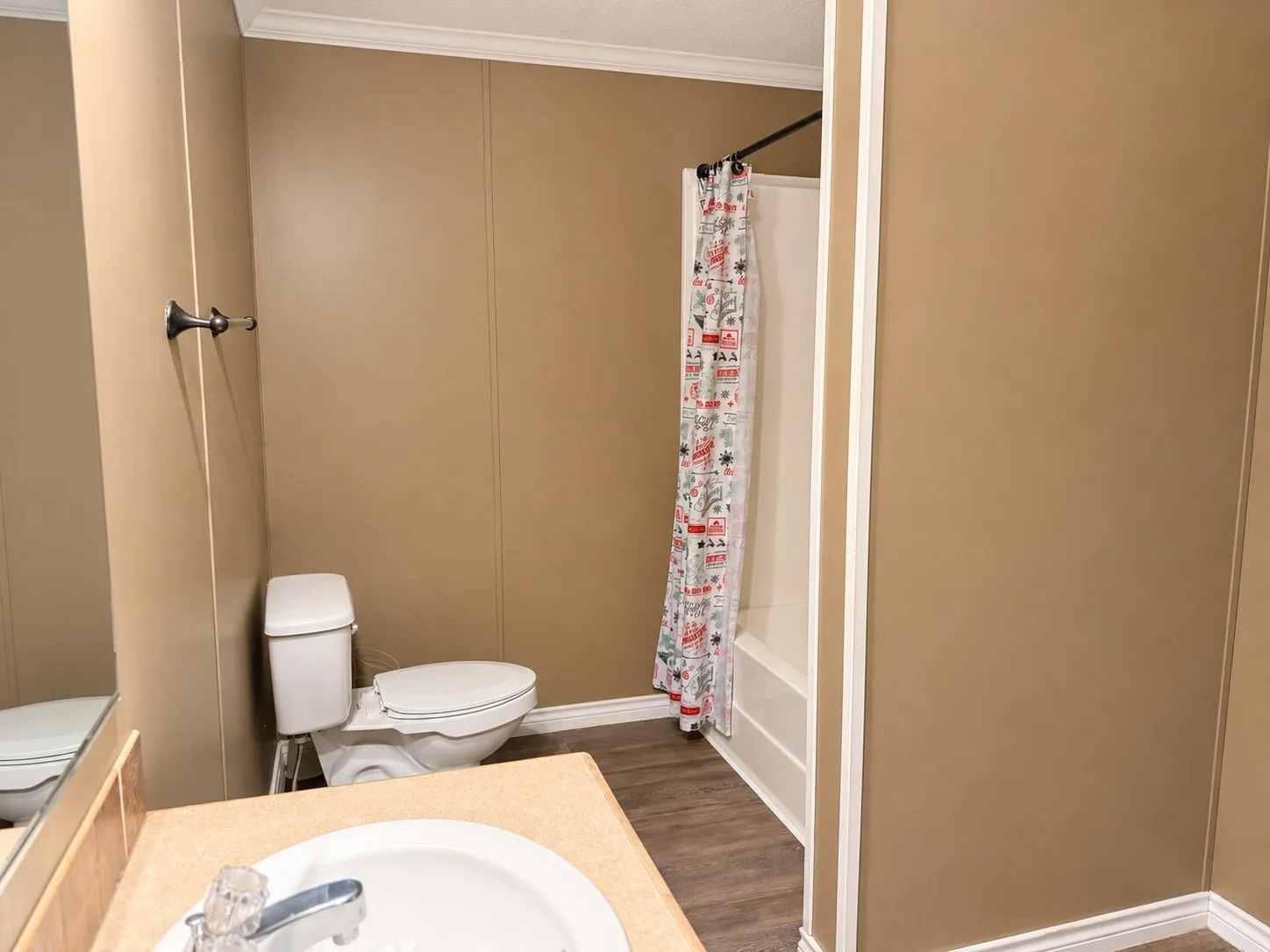 Full bathroom featuring a white toilet, an integrated sink vanity with a light-colored countertop, and a shower-over-tub combination with white subway tile surround