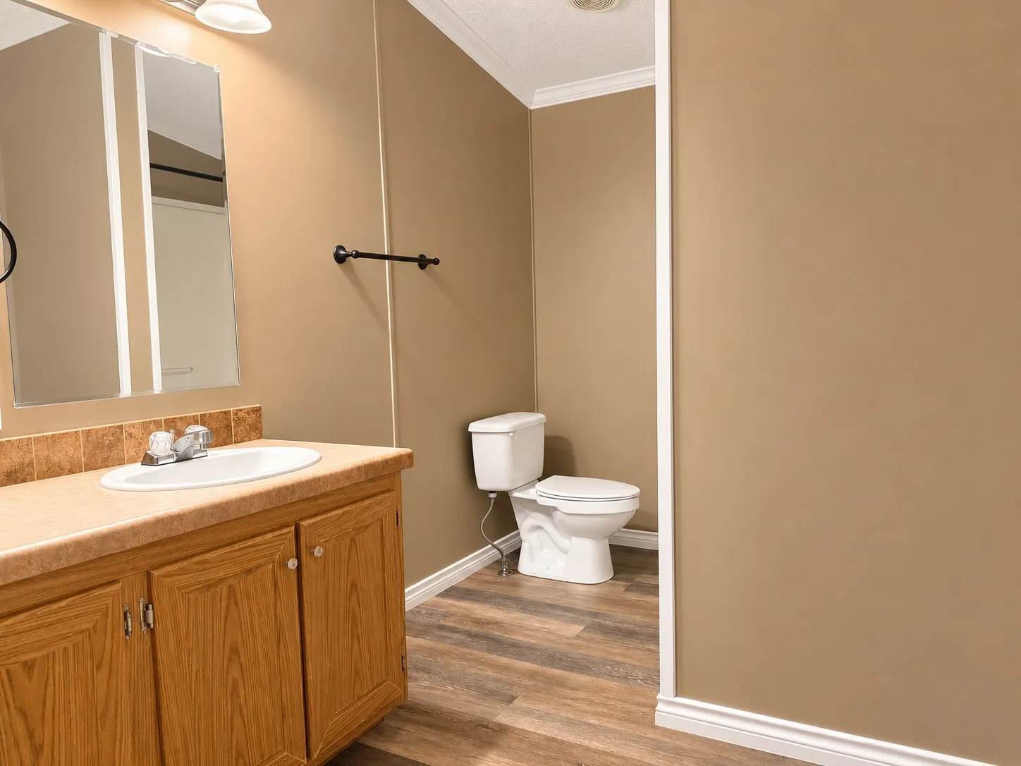Bathroom vanity with an integrated sink, laminate countertop, and wood-finish cabinetry