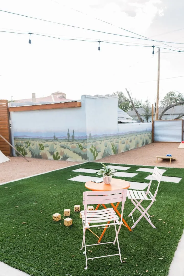 Rear yard featuring artificial turf, stepping stones, and a gravel area