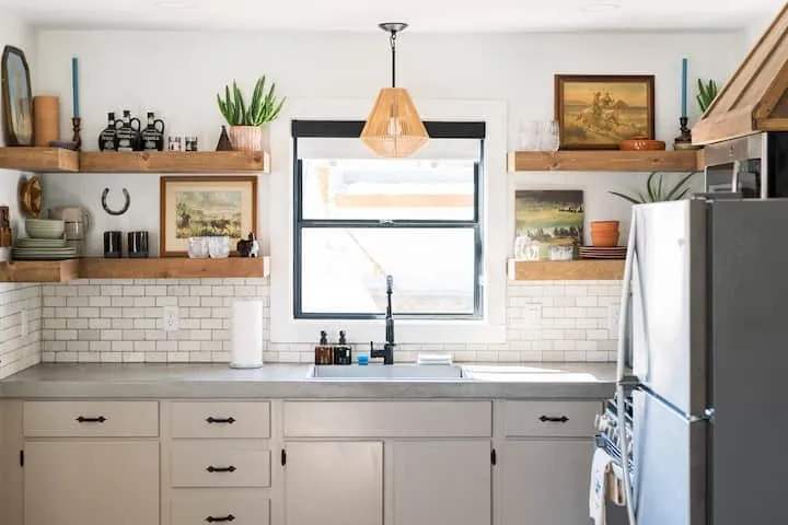 Kitchen featuring a single-basin sink with a matte black faucet, light grey countertops, and white subway tile backsplash