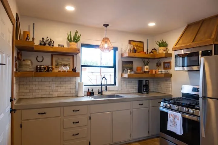 Kitchen featuring light-toned cabinetry, a stainless steel gas range, and a coordinating stainless steel refrigerator