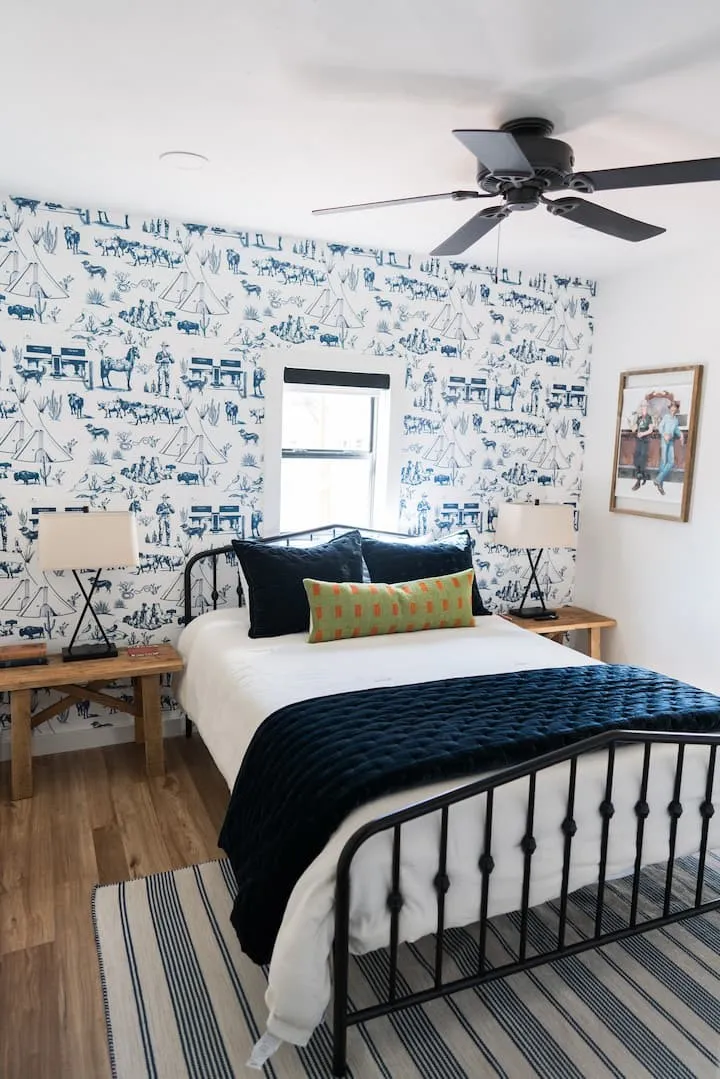 Bedroom featuring accent wall with patterned wallpaper, wood-finish flooring, recessed lighting, and a ceiling fan