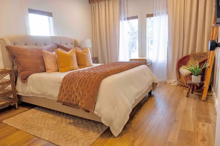 Bedroom featuring wood-finish flooring and multiple windows