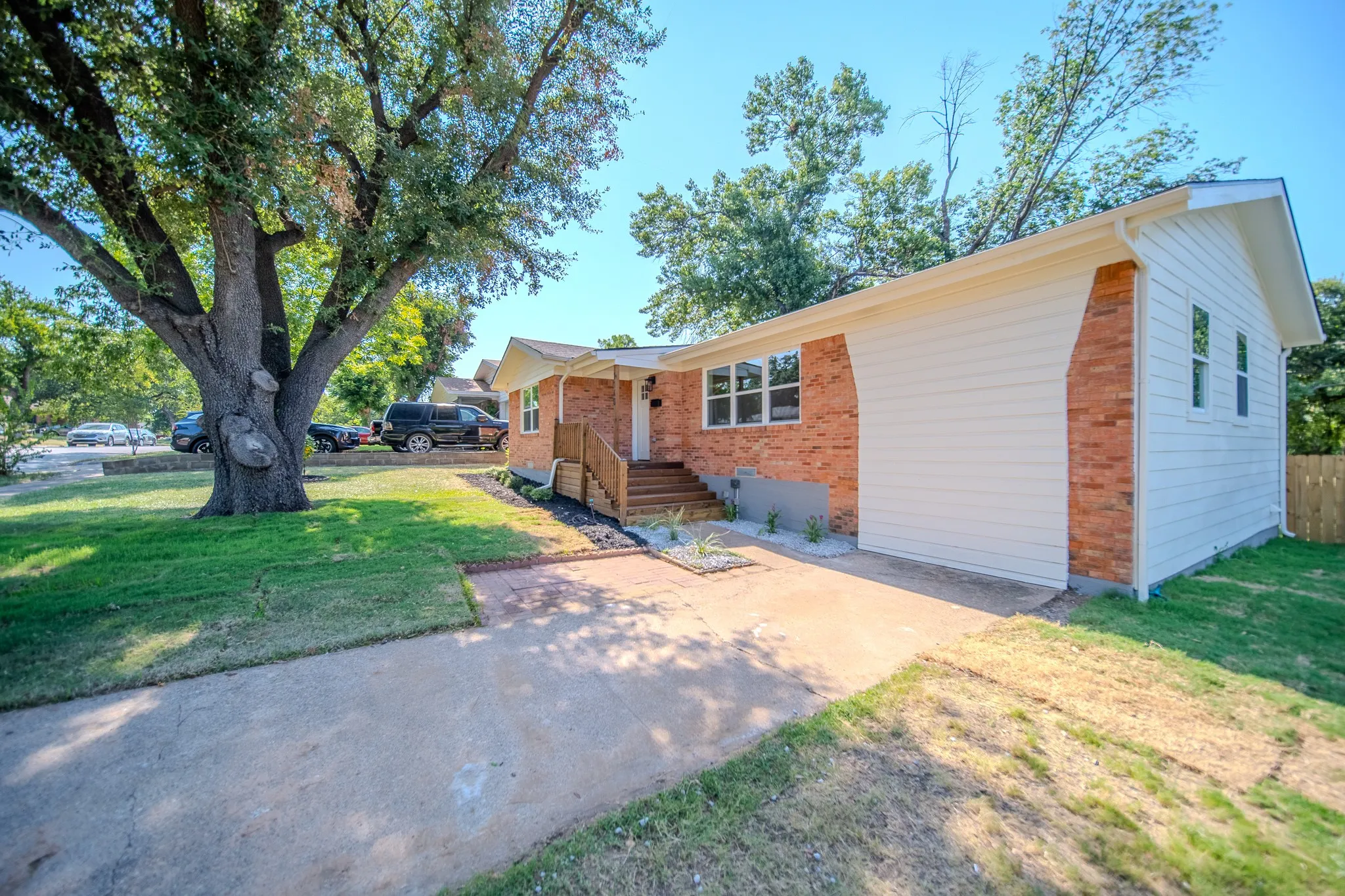 Brick and siding exterior featuring a covered entry with wood stairs and railings