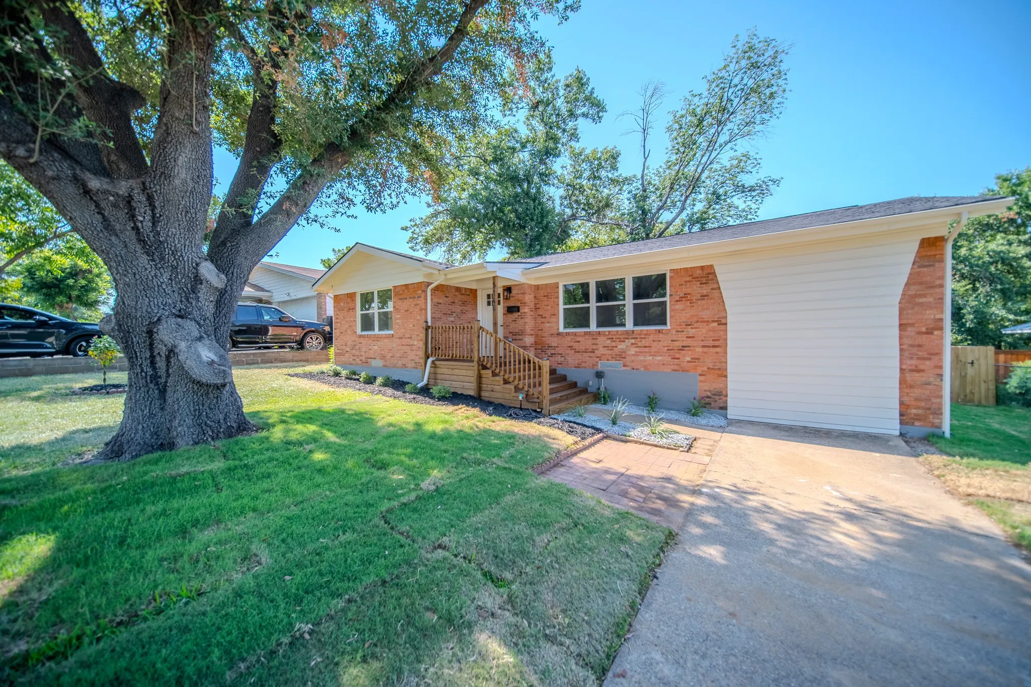 Brick exterior with white siding accents and a concrete driveway