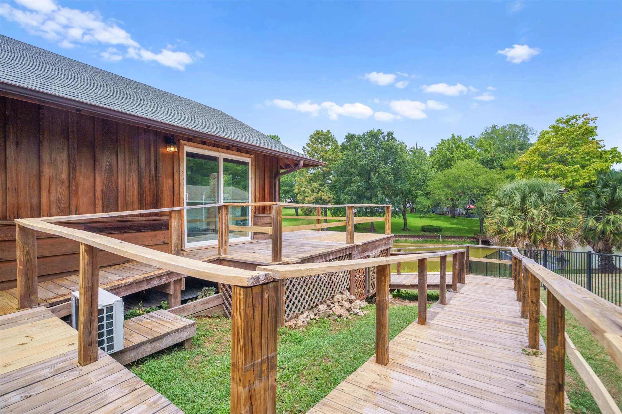Wood-sided exterior featuring a spacious elevated deck with wooden railing
