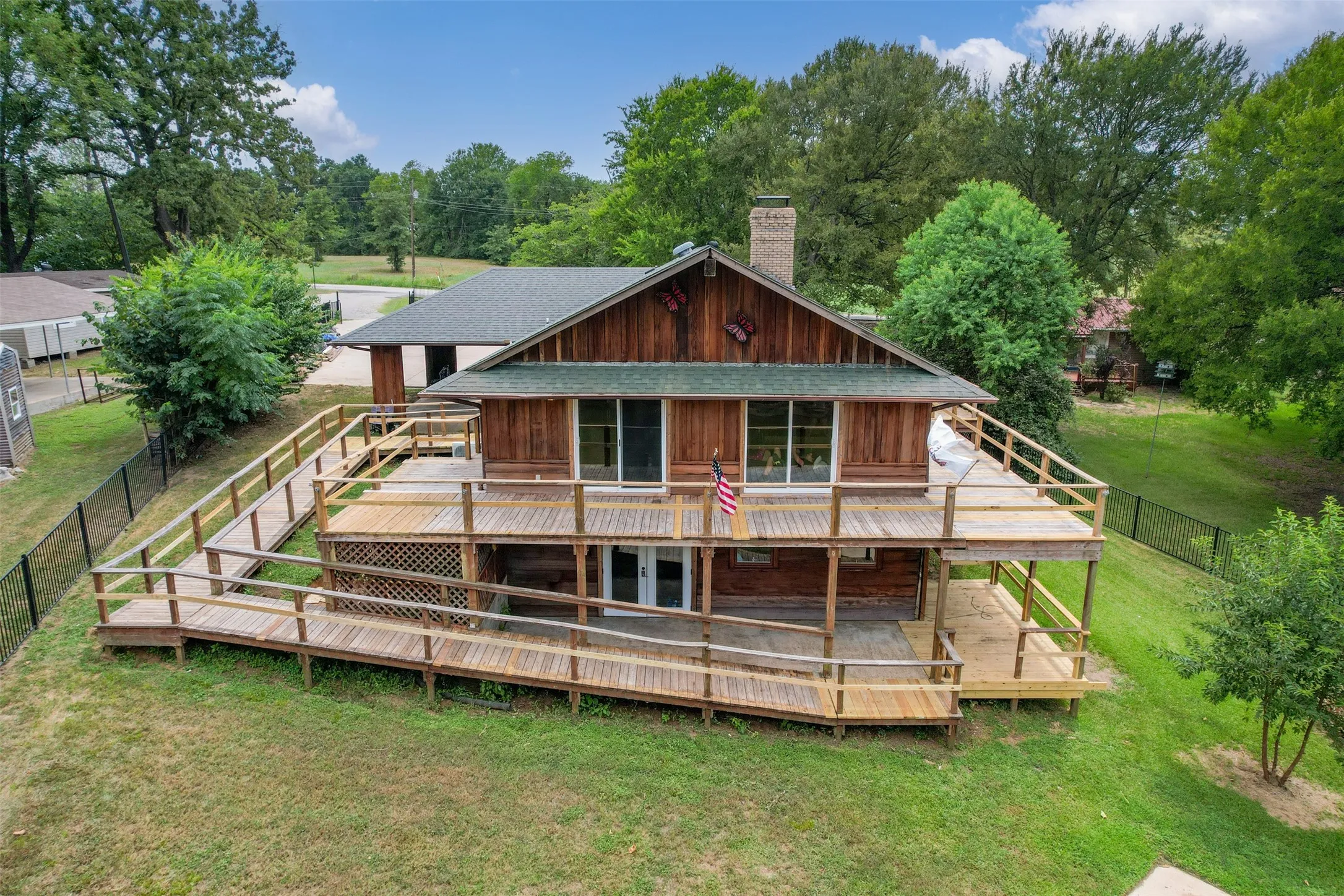 Wood-sided residence featuring a multi-level deck system with integrated wooden ramps