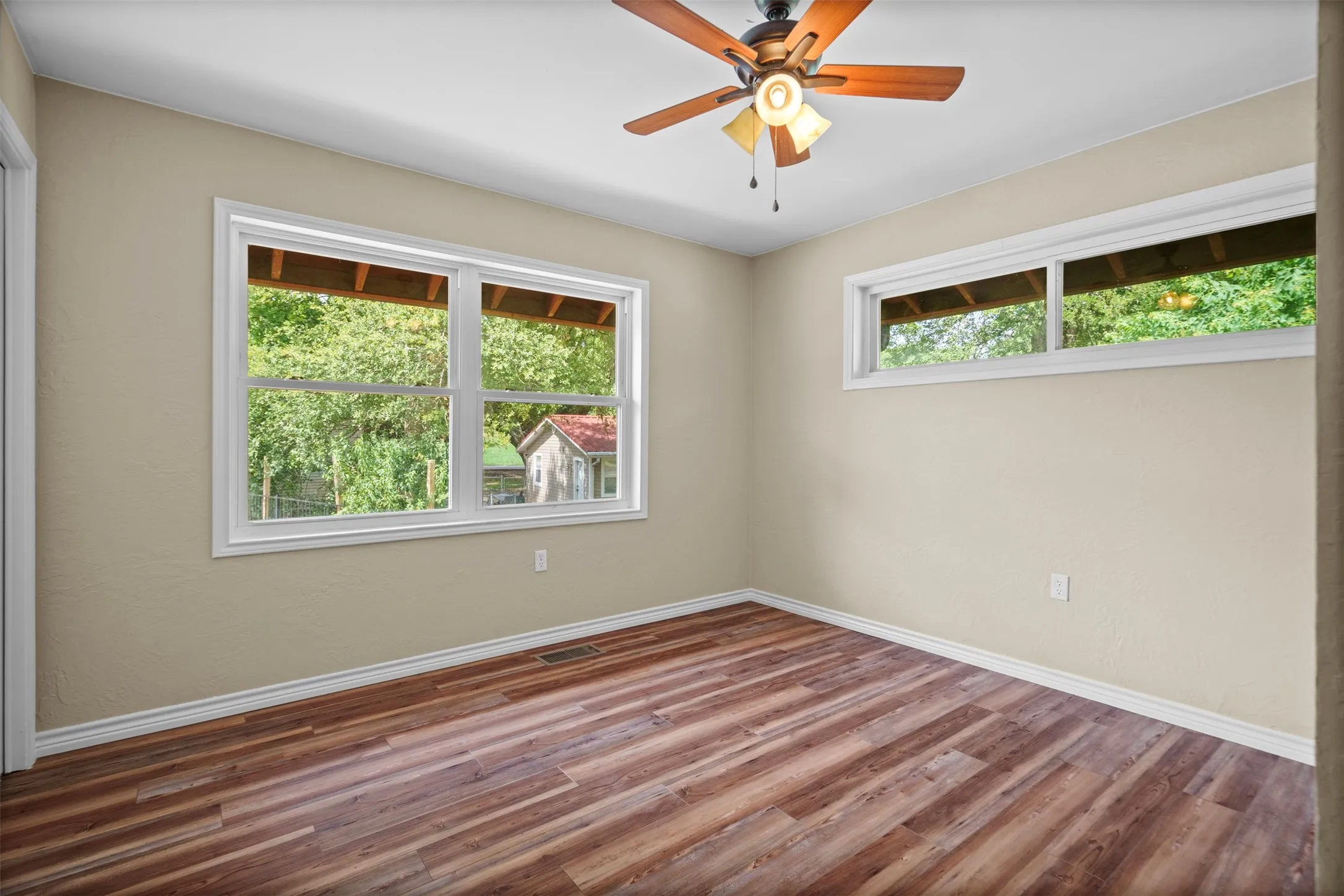Spacious room with wood-finish flooring and neutral wall tones