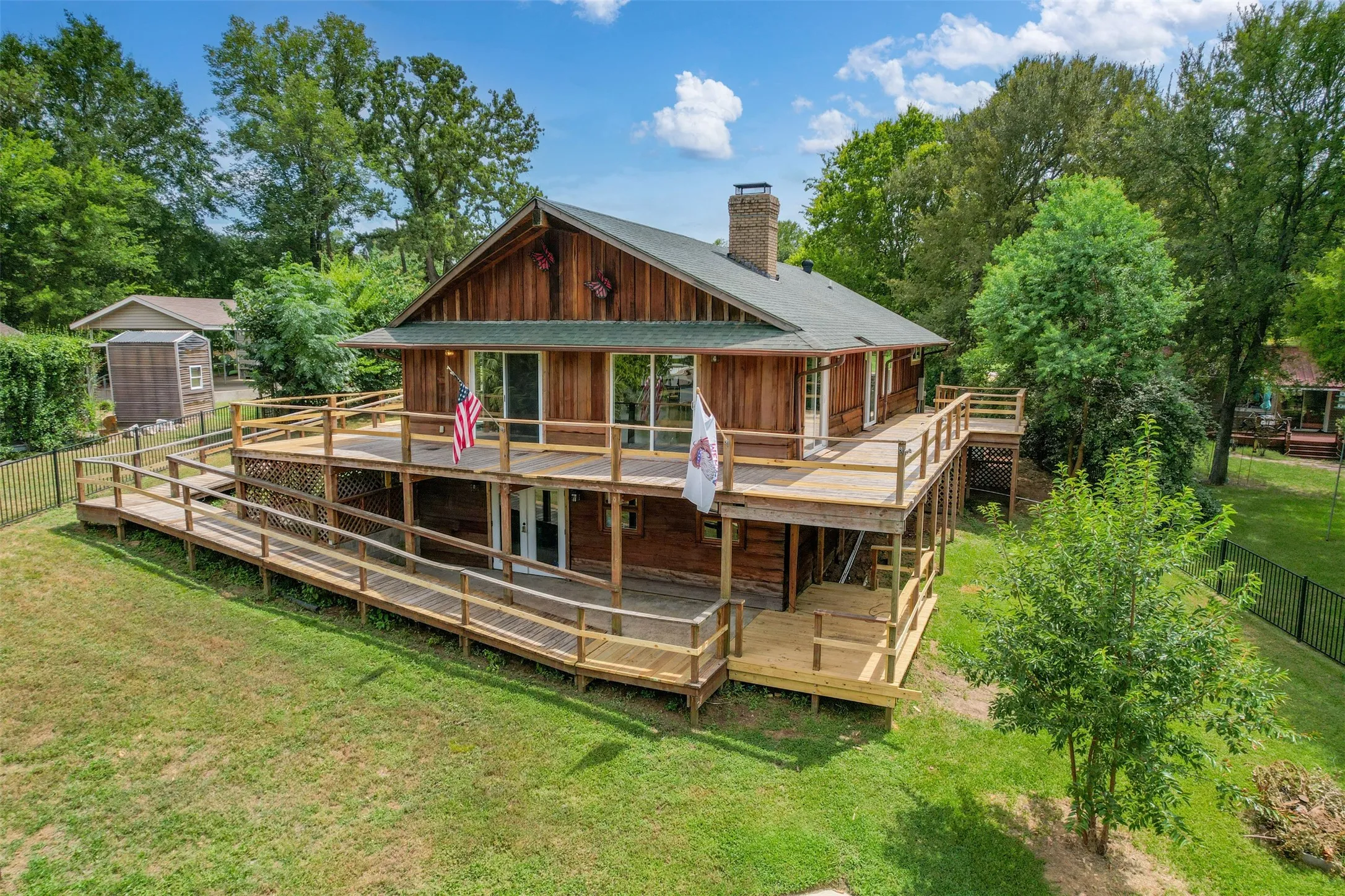 Wood-sided residence featuring a multi-level wooden deck with extensive ramp access and railings