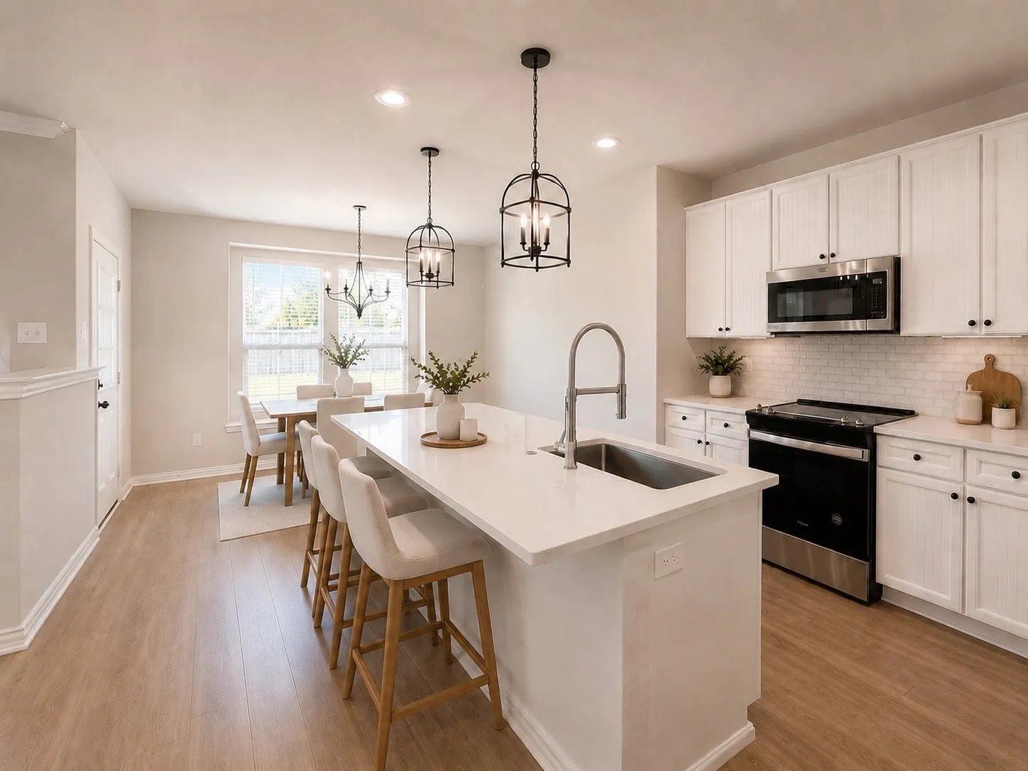 Gourmet kitchen with a large island featuring a stainless steel sink and a gooseneck faucet