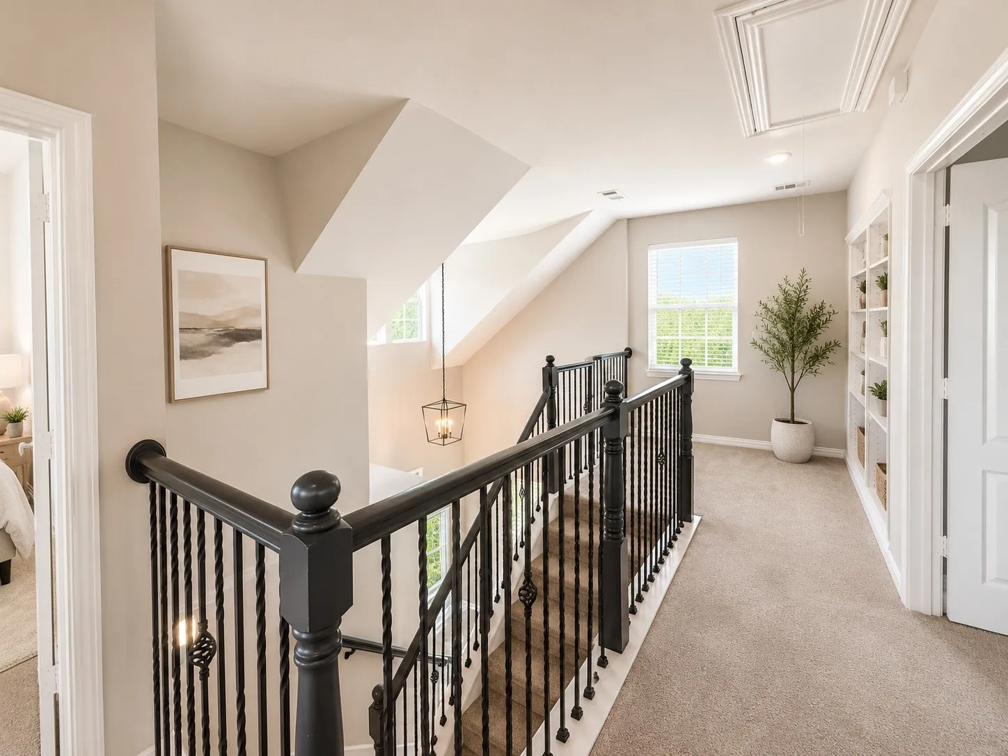 Staircase featuring dark wood handrails and wrought iron balusters