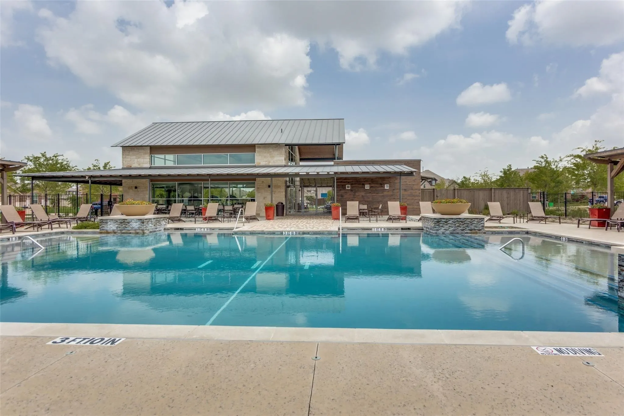 Resort-style swimming pool with concrete decking