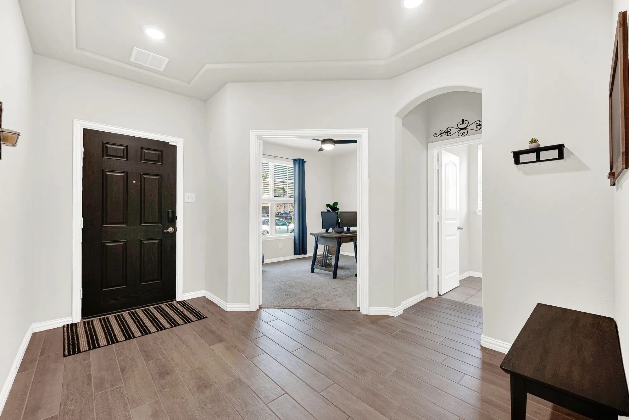 Entryway with wood-finish tile flooring, recessed lighting, and a tray ceiling detail