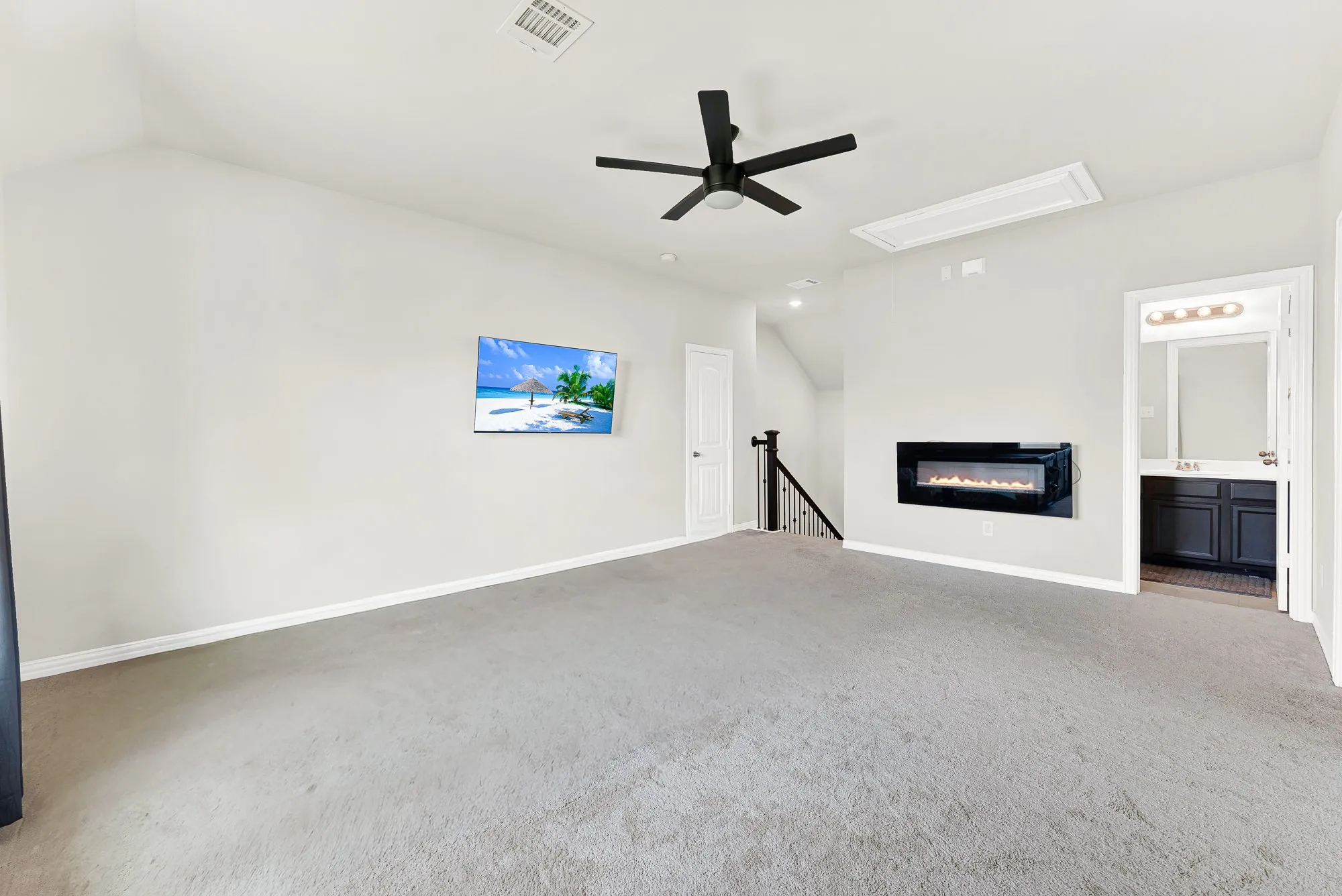 Upper-level bonus room featuring a wall-mounted electric fireplace, sloped ceiling, and a ceiling fan