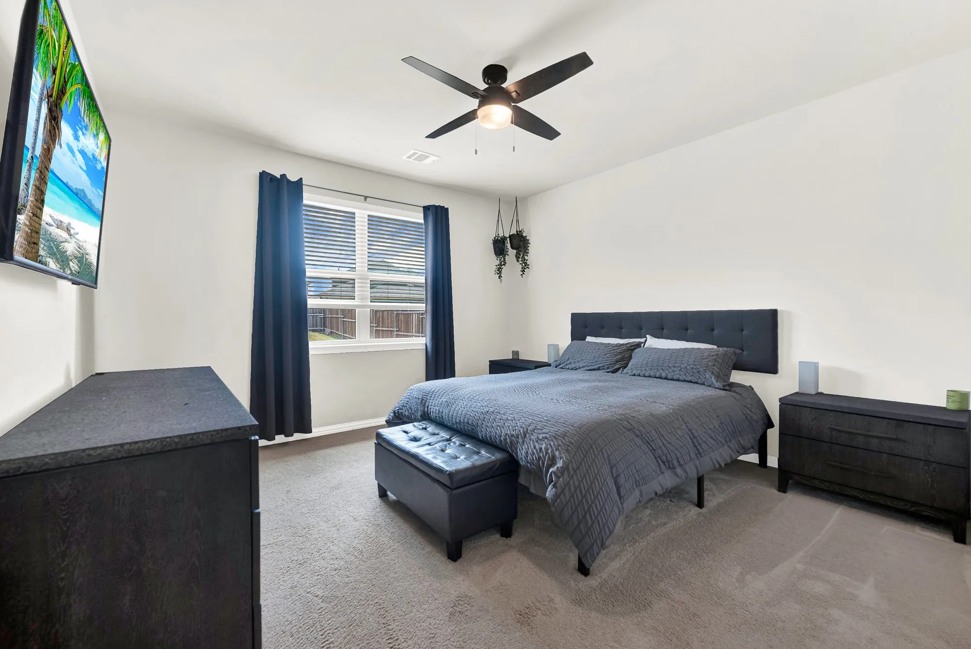 Carpeted room featuring a ceiling fan with integrated lighting, a window with horizontal blinds, and neutral wall tones