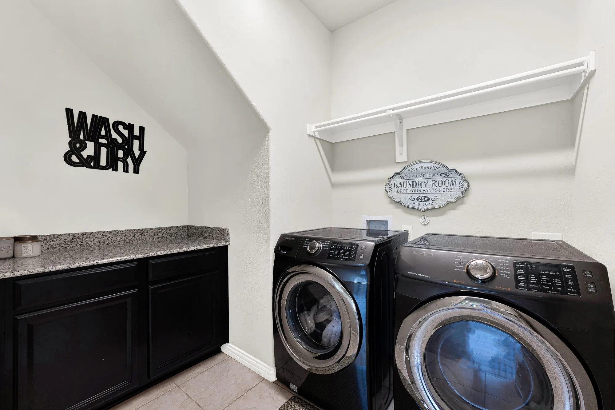 Laundry area featuring built-in cabinetry, a speckled countertop, and a white wall shelf