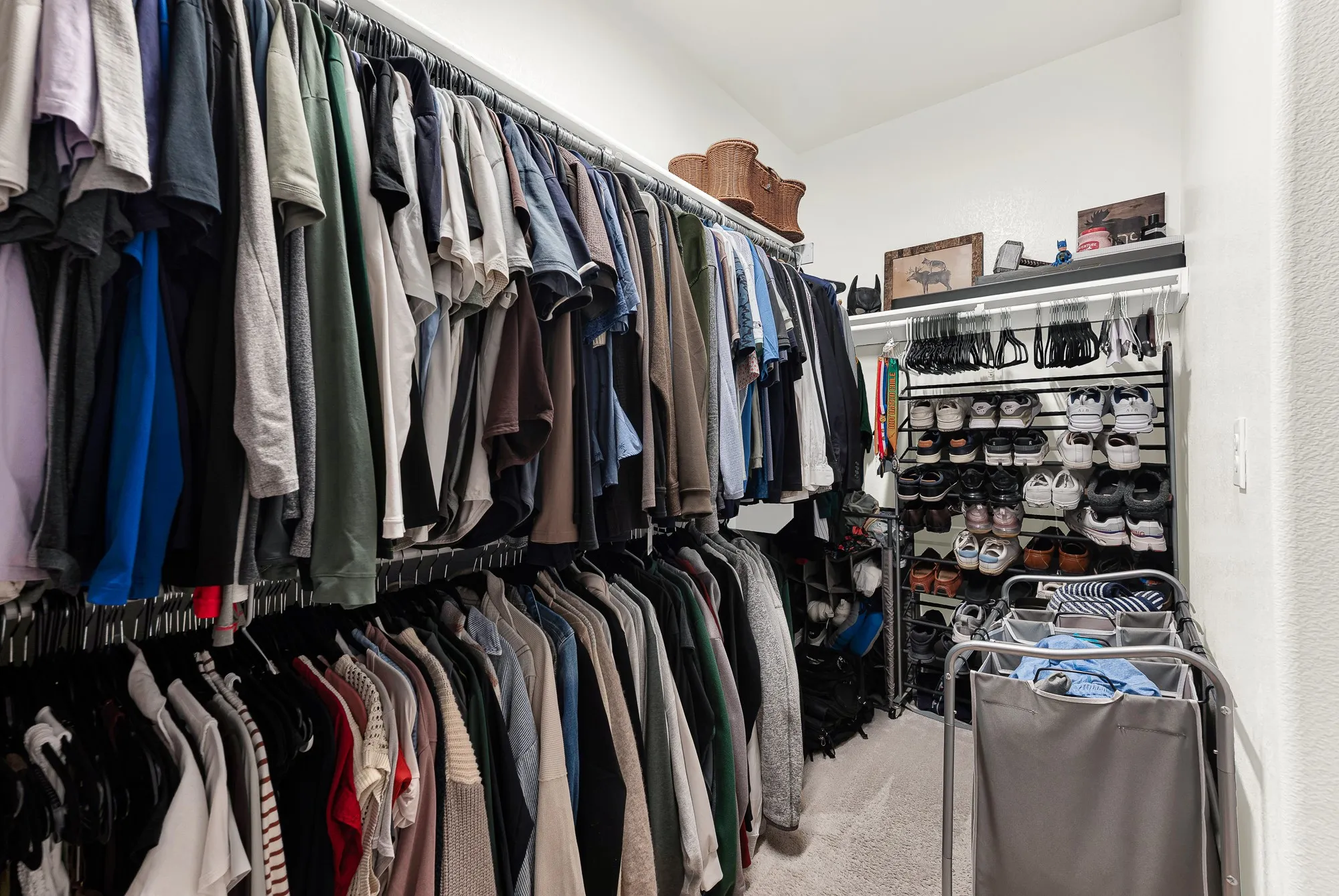 Custom closet system featuring multiple hanging rods, wall-mounted shelving, and integrated shoe storage