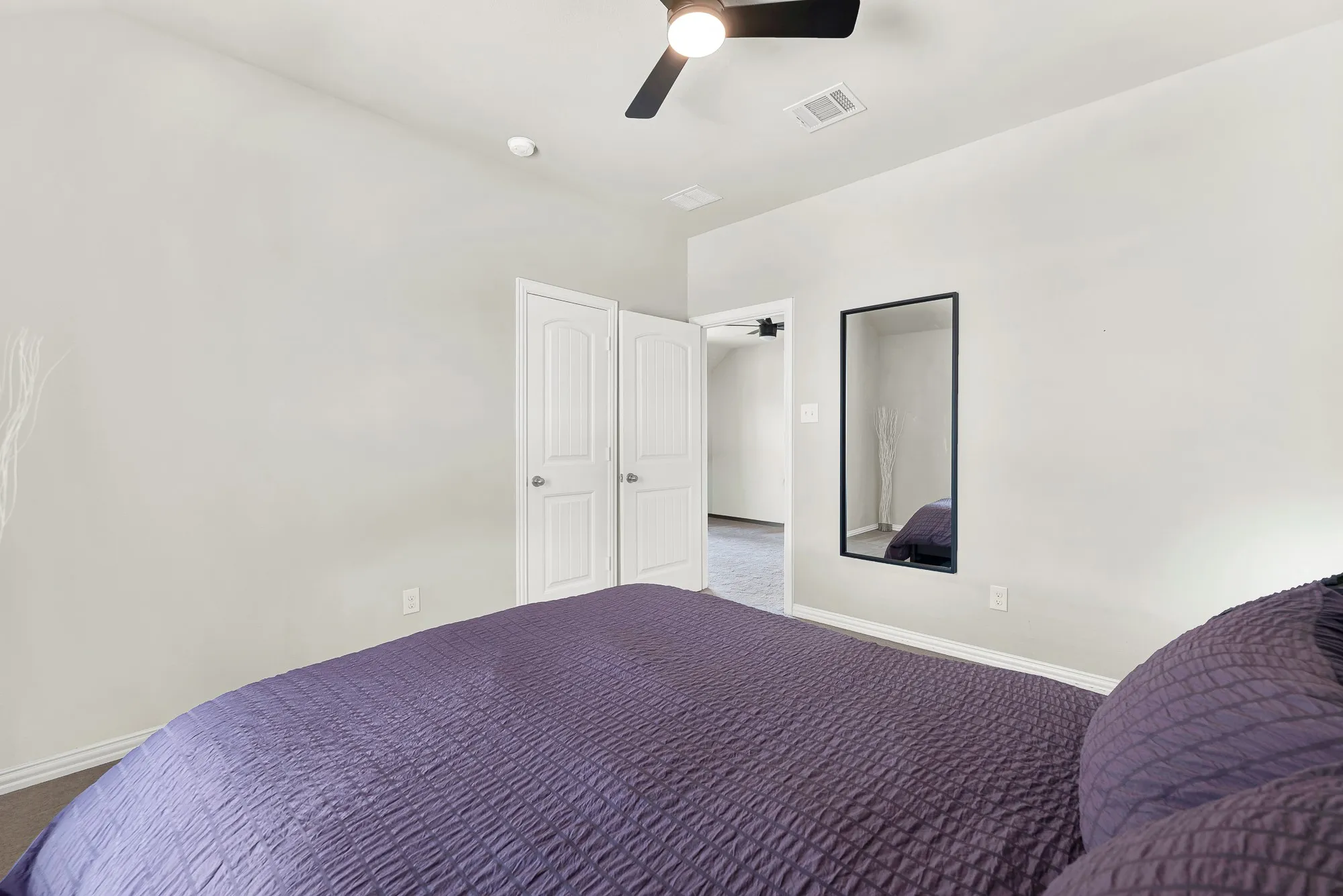 Room featuring white walls, a black ceiling fan with integrated lighting, and carpeted flooring