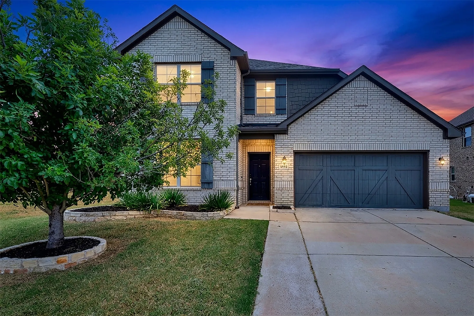 Two-story home with light brick facade and dark trim accents