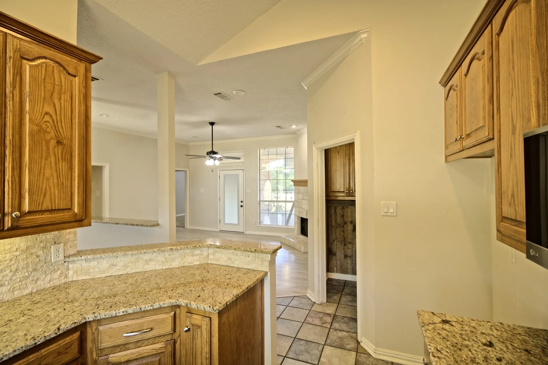 Kitchen featuring wood cabinetry, granite countertops, and a tiled backsplash
