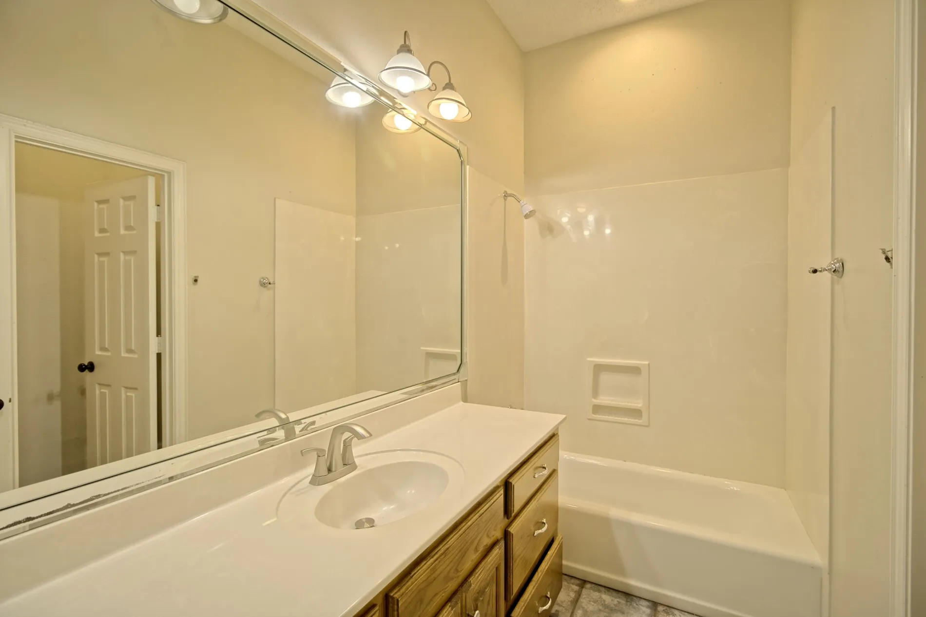 Bathroom featuring a full vanity with a white countertop, an integrated sink, and a wood-finish cabinet with drawer storage