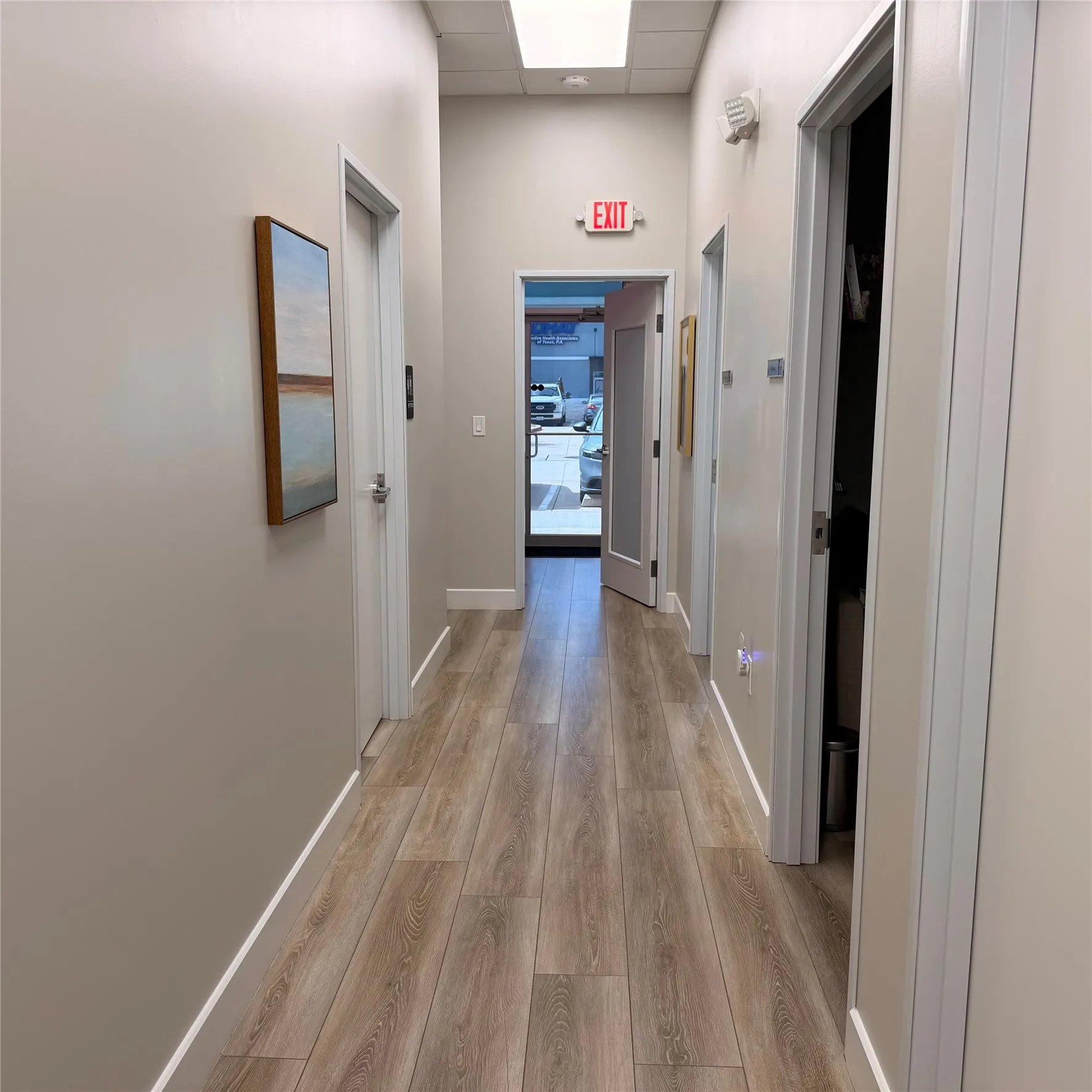 Hallway featuring wood-finish flooring, recessed lighting, and a white baseboard trim