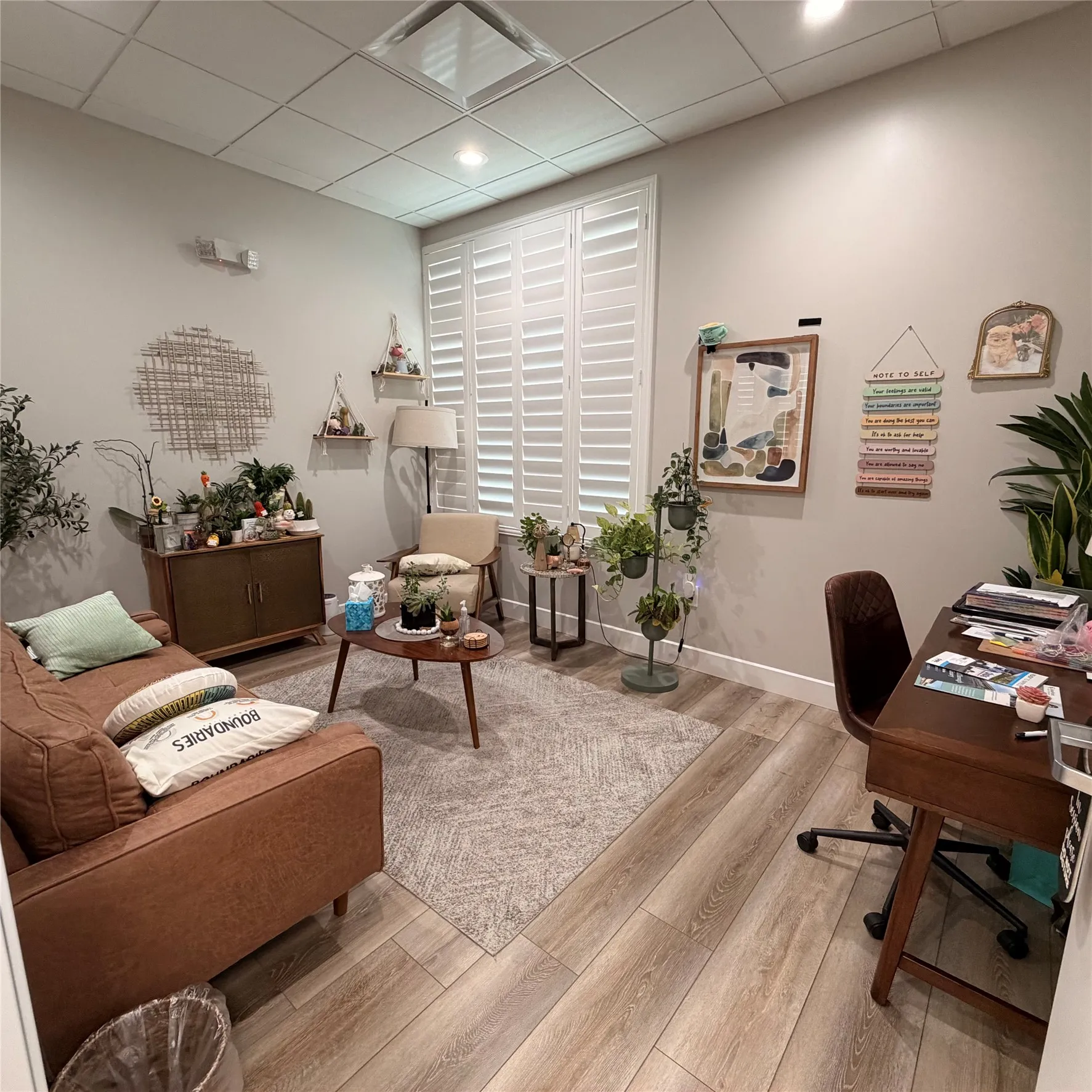 Well-appointed room featuring wood-finish flooring, white plantation shutters, recessed lighting, and a neutral wall palette