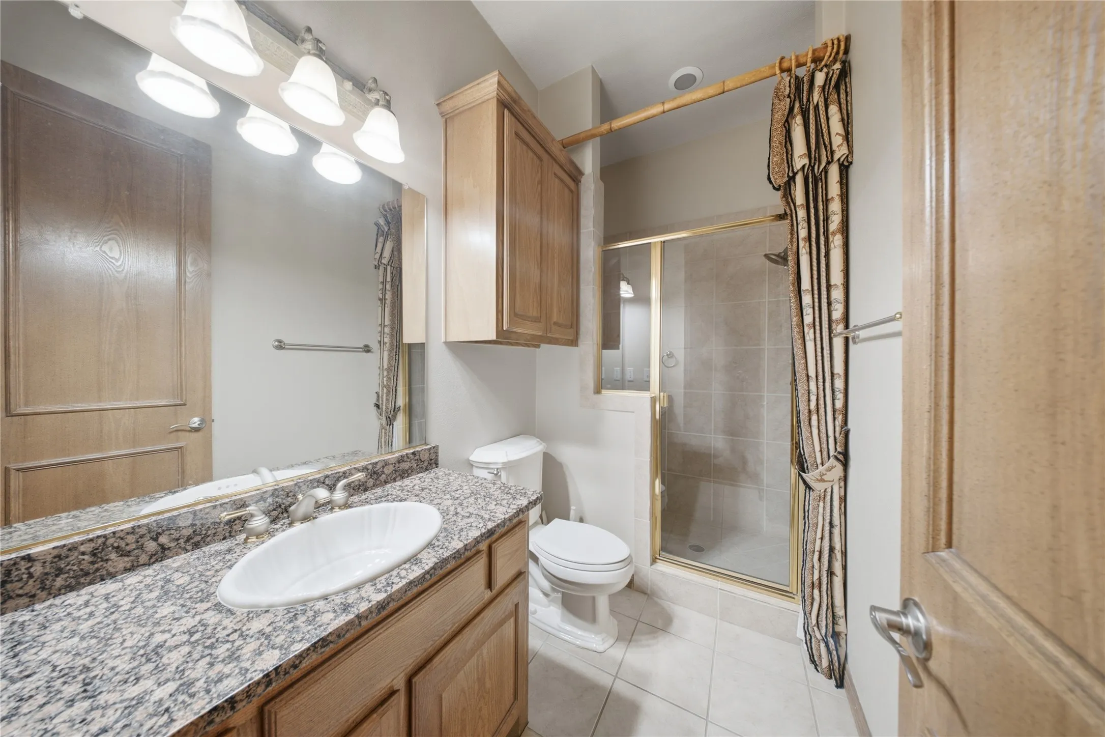 Bathroom vanity featuring a granite countertop with an undermount sink and traditional wood cabinetry