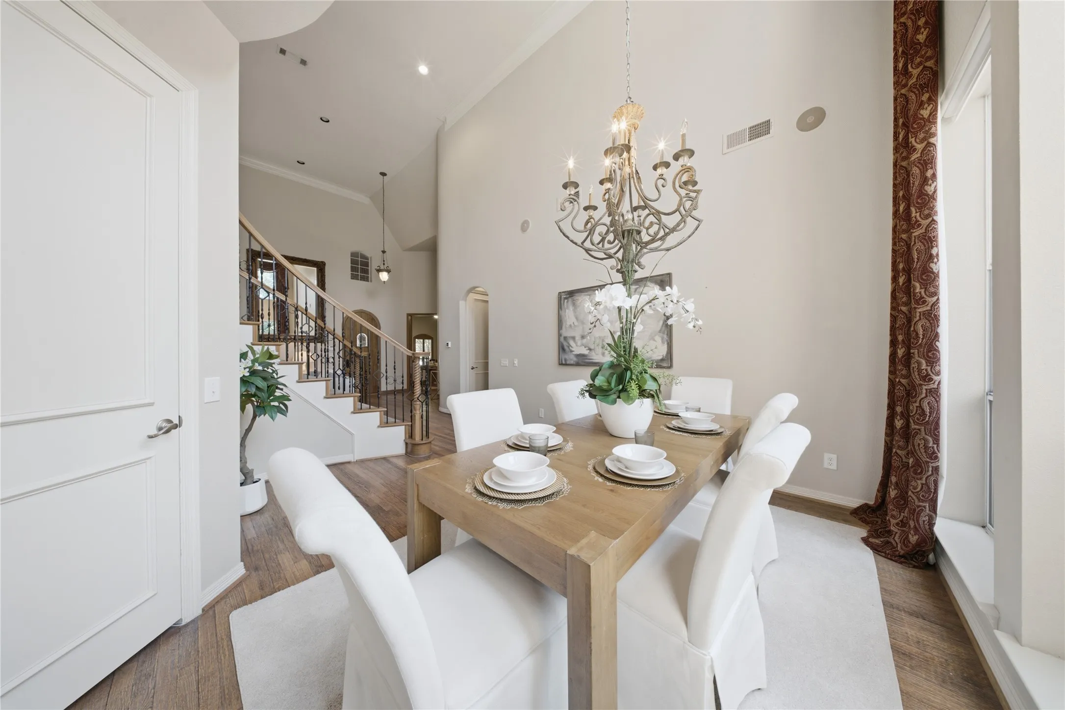 Spacious dining area featuring wood-finish flooring and a high vaulted ceiling