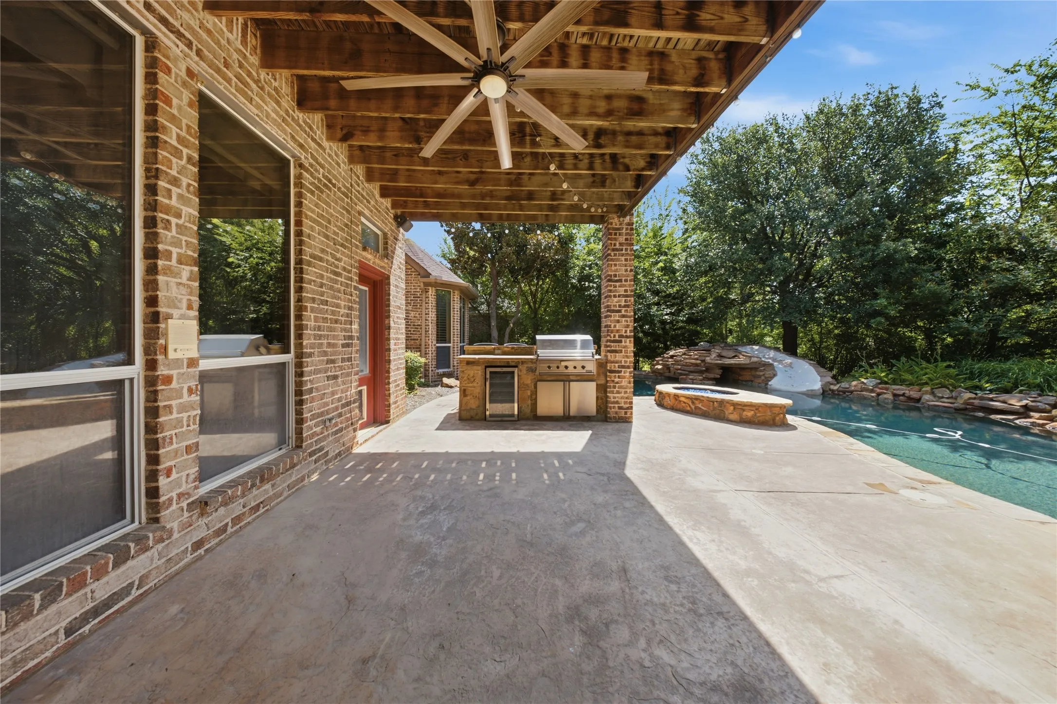 Covered patio with a wood-plank ceiling and a ceiling fan