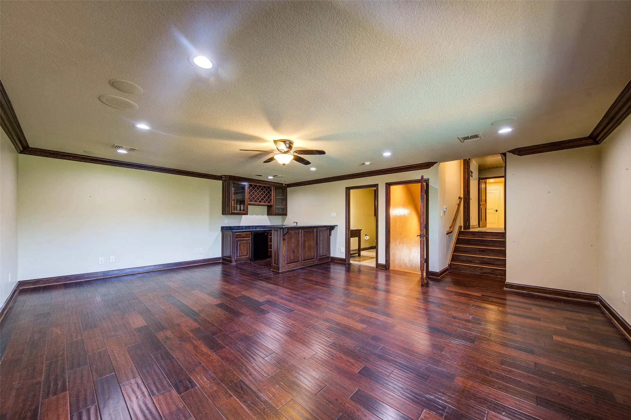 Expansive upstairs game room or living area with wet bar and full bathroom and bedroom and craft room or storage area