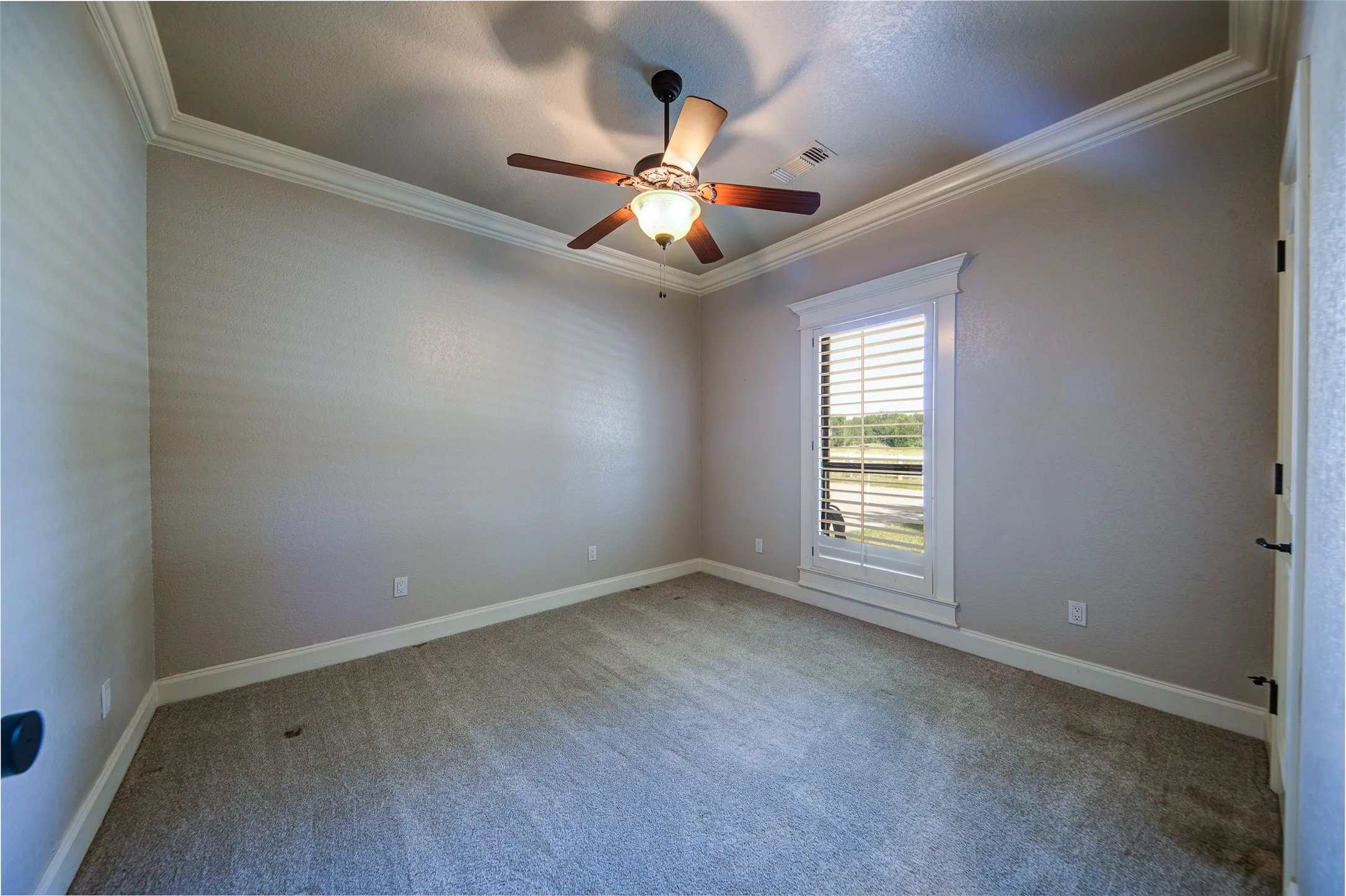 Bedroom 2 featuring a ceiling fan with light fixture, crown molding, and neutral wall paint
