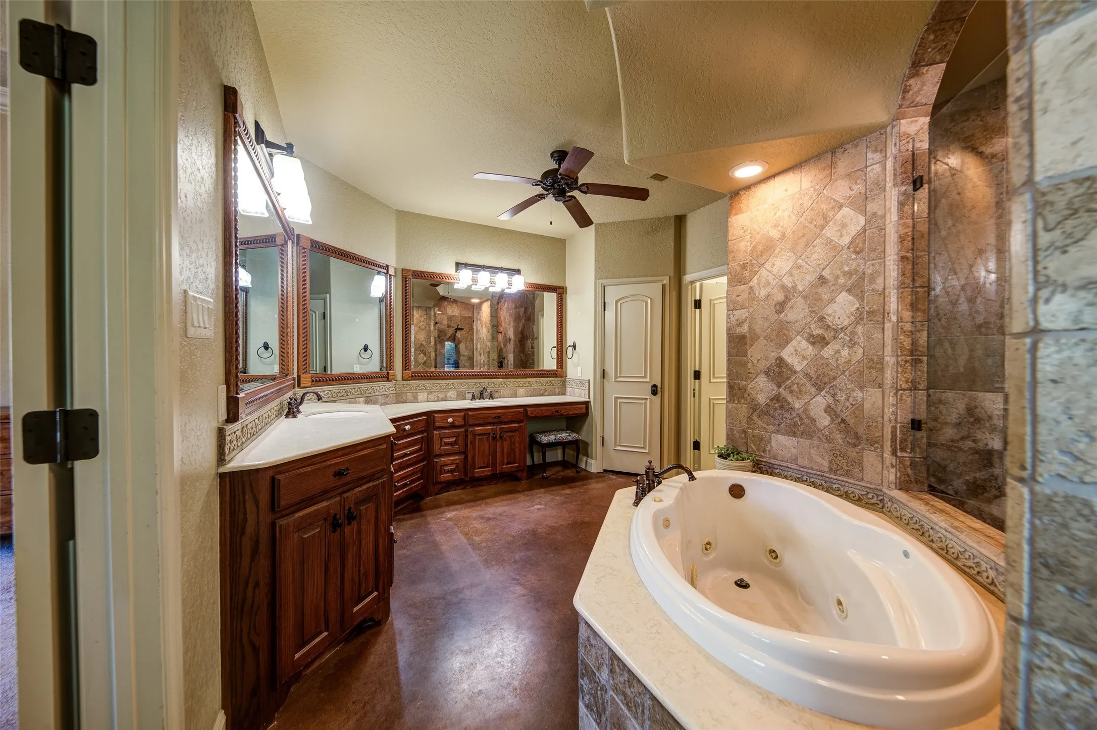 Spa-inspired bathroom featuring a jetted soaking tub with a tiled surround, a glass-enclosed shower with full-height tile, and a large privacy window with glass blocks