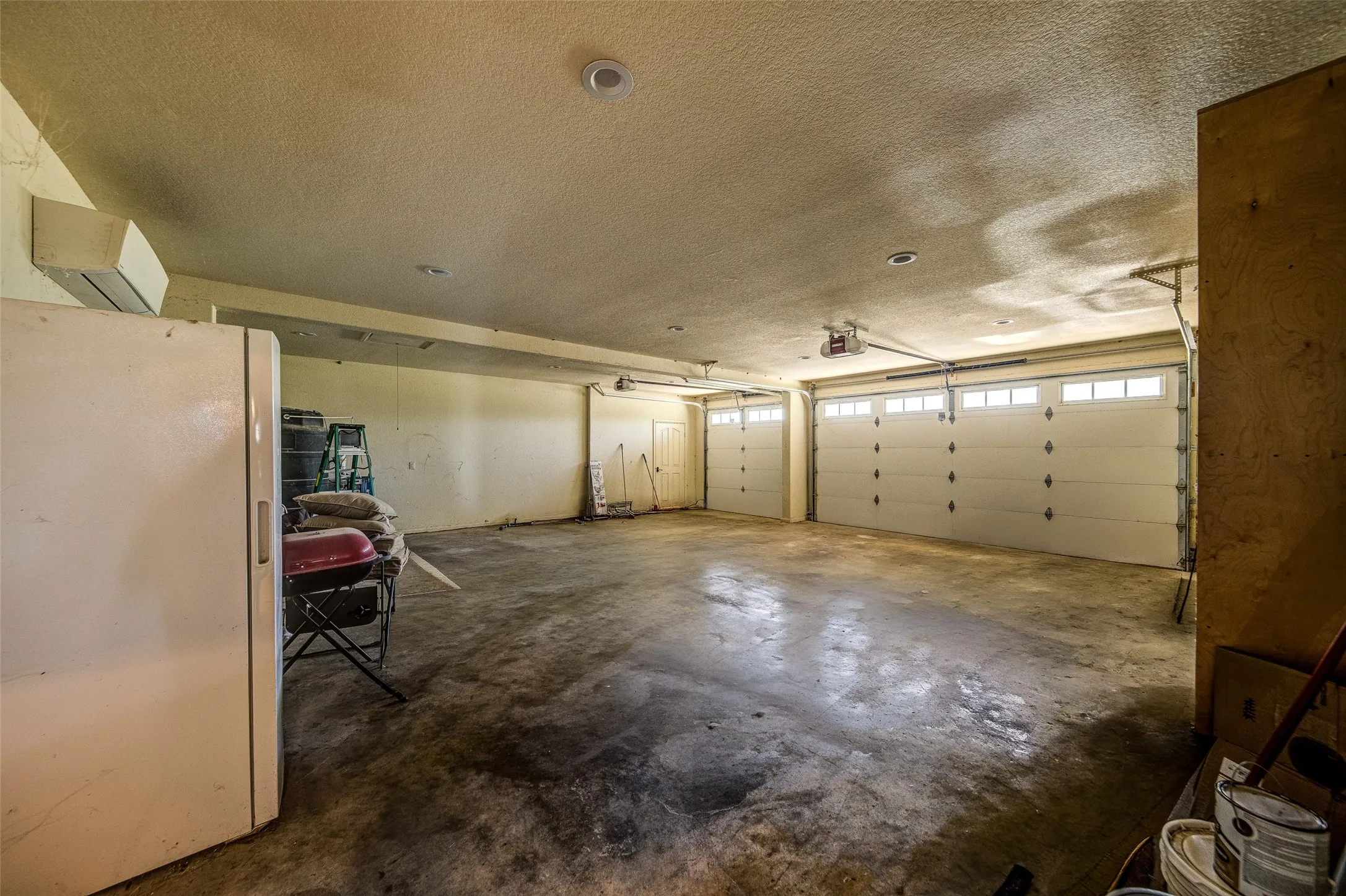 Two garage doors with upper window panels and a storm shelter