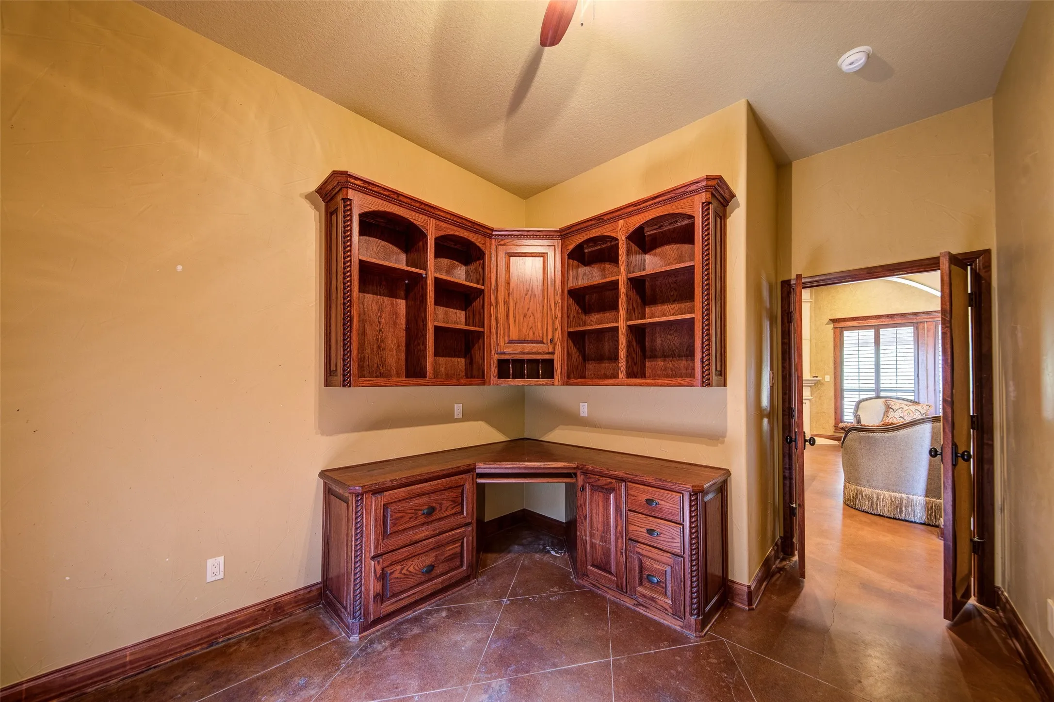Built-in corner desk with custom wood cabinetry and shelving, offering integrated storage